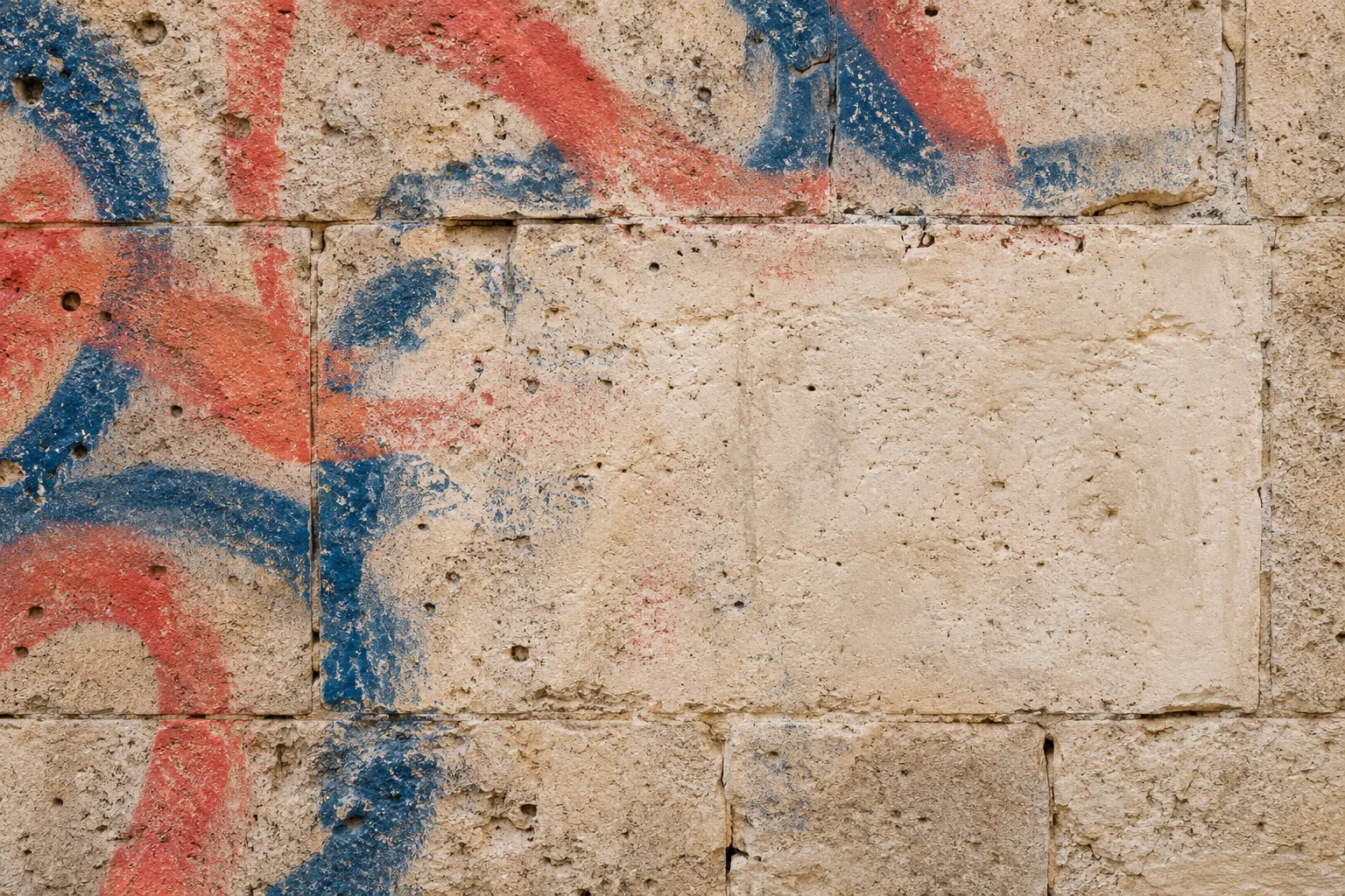 Illustration of graffiti on pale stone with a cleaned test patch and residual staining in the pores.